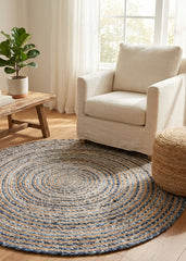 Round braided jute rug in a living room with a beige armchair and wooden coffee table.