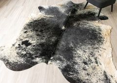 Black and white cowhide rug on a wooden floor