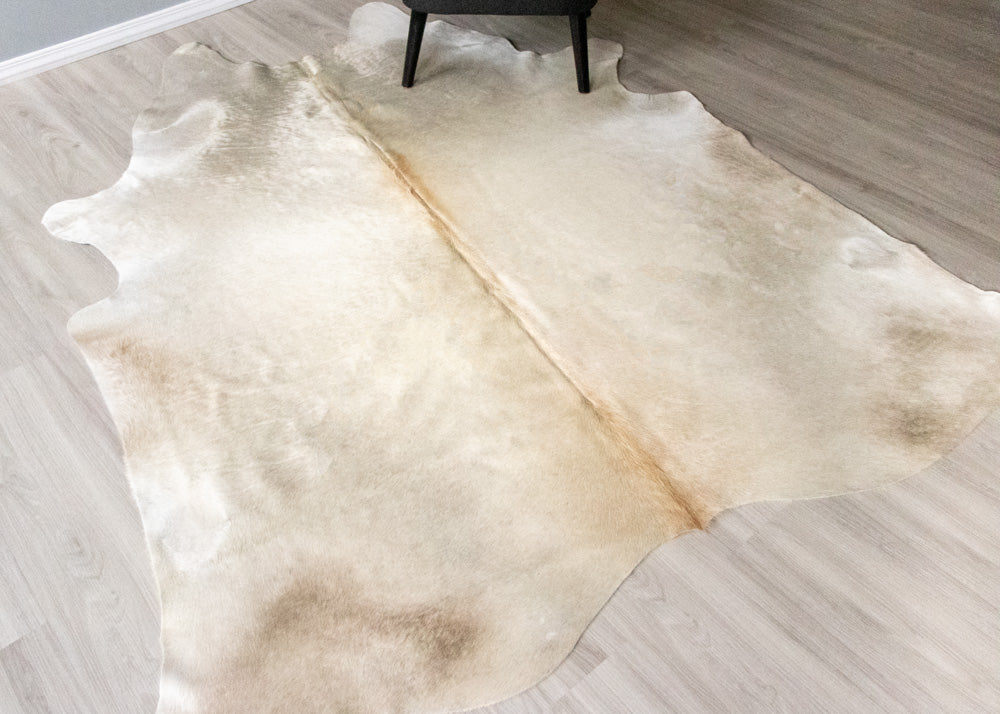 champagne Beige cowhide rug on a wooden floor