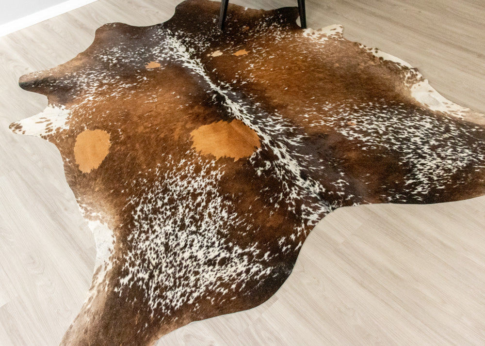 Brown and white cowhide rug on a light-colored floor