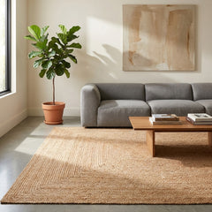 Living room with a gray sofa, wooden coffee table, and rectangular jute rug.