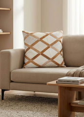 Tan and ivory lattice cowhide cushion styled on a beige sofa in a modern neutral interior