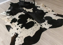 Black and white cowhide rug on a wooden floor