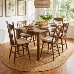 Dining room with wooden table and chairs on a oval jute rug