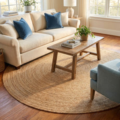Living room with beige sofa, round plain natural jute rug, and round jute rug.