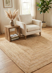 Beige armchair with a wooden side table and decorative elements in a room with a square jute rug.